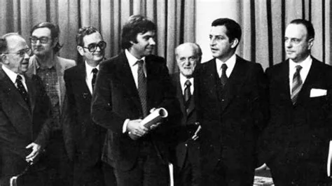 Foto en blanco y negro de un grupo de hombres con traje formal Descripción generada automáticamente